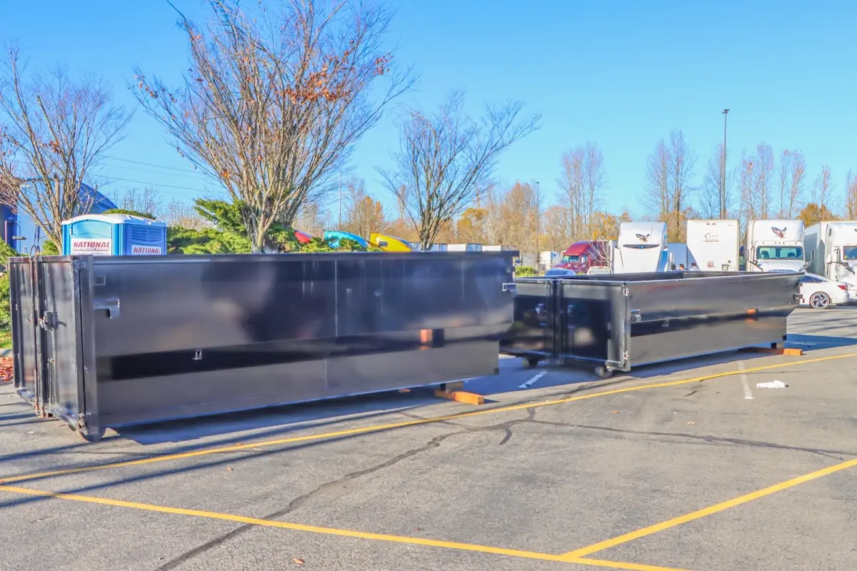 Professional dumpster rental service with roll-off container on residential driveway in Bloomfield